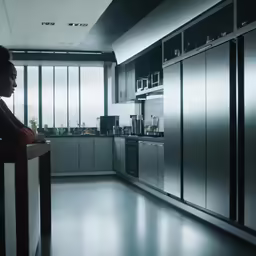 the woman is staring out of her kitchen