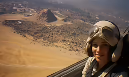 a female pilots smiles as she flies through the air