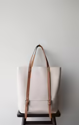 a large beige tote bag sitting on top of a chair