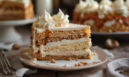 two layer cakes with frosting, nuts and mering sit on a table