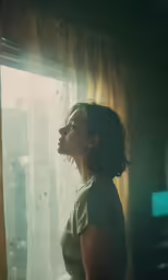 a woman looks up from her window with sunshine shining through