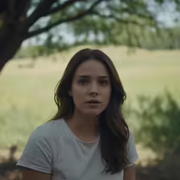 a woman stands outside staring off into the distance