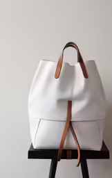 a white and brown bag sitting on top of a chair