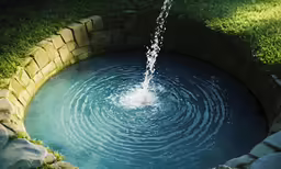 an image of a man made pond with water shooting from it