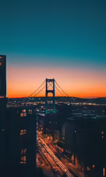 view of a city with a bridge at sunset