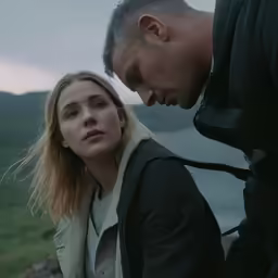 a young man looking down as a woman is looking at her