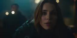 a woman in the dark is looking ahead
