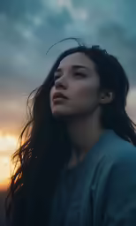 a woman standing with her hair blowing in the wind