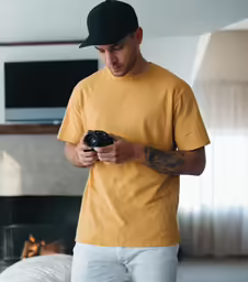 a man looking at his camera while standing in front of the fireplace
