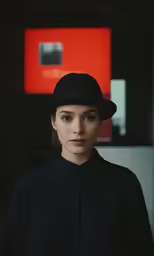 woman wearing black hat standing with abstract background