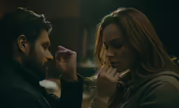 a man holding his watch while the woman puts the ring on him