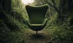 the green chair is sitting in the middle of a dirt path
