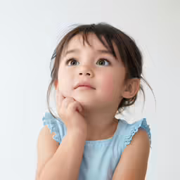 a small child with her hand on her chin