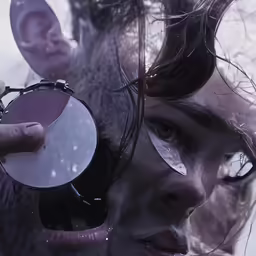 woman holding out her face as mirror reflects skin on it
