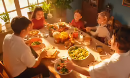 a group of children sitting around a table eating and drinking
