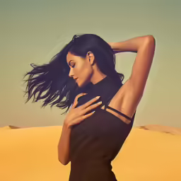 woman in black dress holding hair while standing on beach