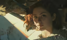 a woman holding two knifes looking into the distance