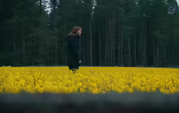 a man standing in a field next to trees