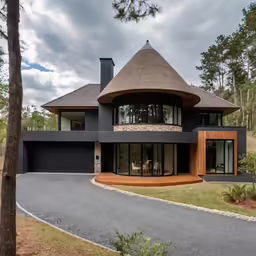 a nice house with big windows is near the woods