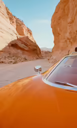 an old yellow car is parked in a desert