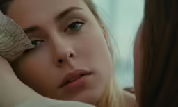 a young woman is looking into the mirror