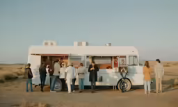 people gathered in front of a white mobile food truck