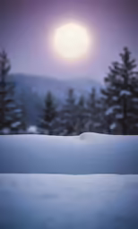 snow covered hillside with full moon in the background