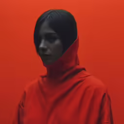woman in red with black hair and face in red