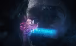 woman looking at the camera with bright blue and pink objects in her hands