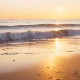 the sun rises over a beach where there are wave tails