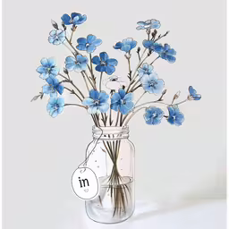 a clear glass vase with blue flowers in it,a mason jar filled with blue flowers on top of a table