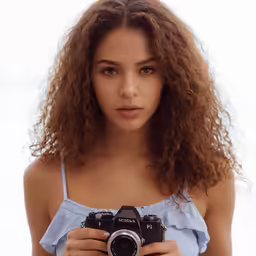 a woman is holding up a camera