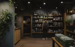 a woman standing in a shop looking at bottles
