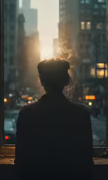 a woman sitting in front of a window looking out at the city
