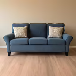 a blue couch is against the wall next to the window