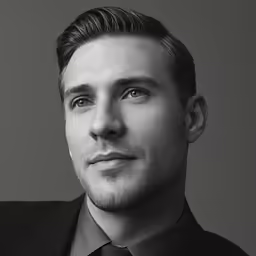 black and white photo of man with dark shirt and tie