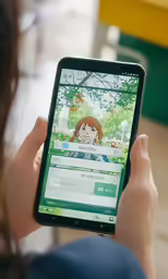 a person holding up a phone displaying an image of a girl