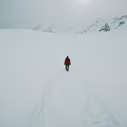 a person walking down the middle of a snow covered hill
