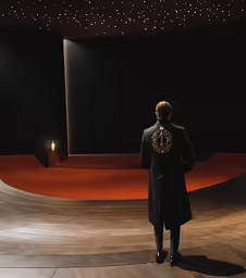 a man standing on a concrete floor next to a lighted stage