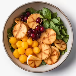 the bowl contains some fruit and greens