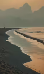 a person stands on the edge of an ocean beach