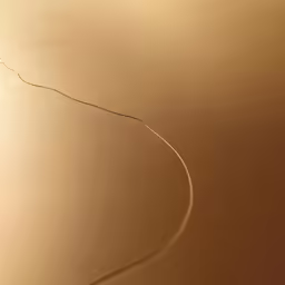 the bottom of a brown metal object with a long wire hanging off it