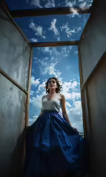 a woman in a blue dress stands in the doorway