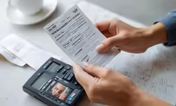 someone with a person sitting down holding a receipt