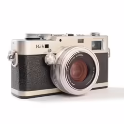 a brown and silver camera sitting on top of a white surface
