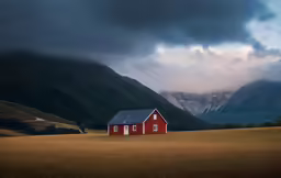 a house in a grassy field with a mountain background