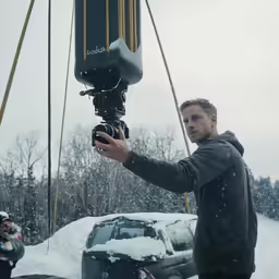 the man is filming outside in the snow