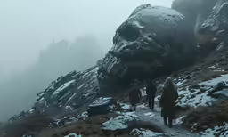 people treking up a mountain on a snowy day