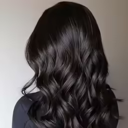 a woman with black hair has wavy brown hair