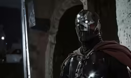 a man wearing a black suit and helmet with a cape